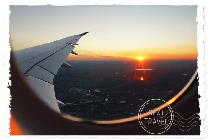 飛行機の窓から朝日が登っている様子